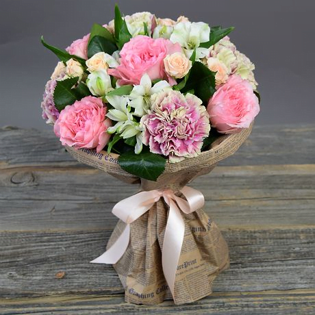 Нежный букет собран из крупноголовых и кустовых роз, альстромерии и гвоздики, упакован в крафтовую бумагу.