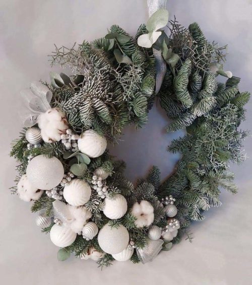 The wreath is made up of spruce branches canadian blue spruce, Christmas decorations, cotton, dried flowers.