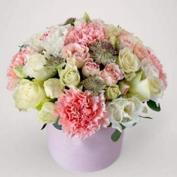 A box with delicate carnations and a mix of seasonal flowers.