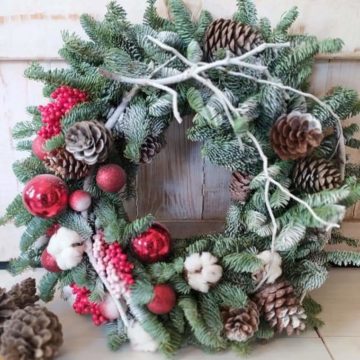 The wreath is assembled from Canadian blue spruce branches, Christmas-tree decorations, cotton, dried flowers.